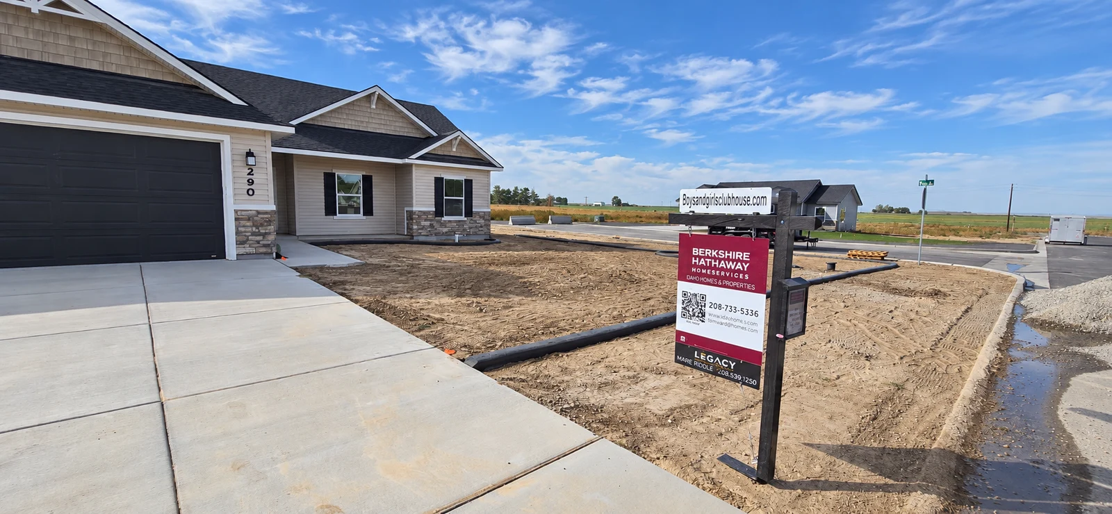 Wide view of the community home with concrete curbing running beside the driveway and across the broad front yard.