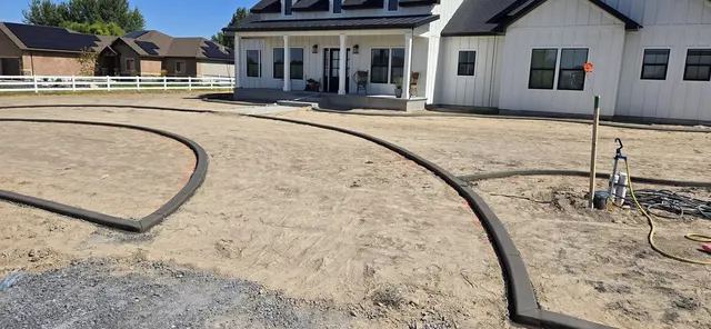A large fresh curve encloses a bare front-yard bed beside a house.