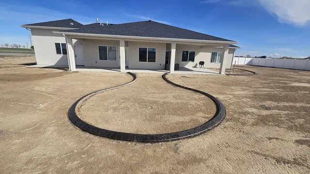 A large rounded curb with a narrow neck extends toward a covered house frontage.
